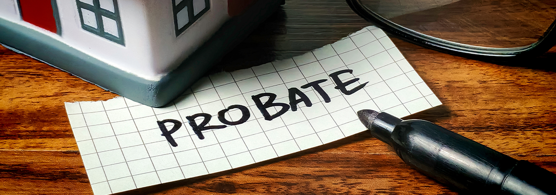 Probate written on piece of paper and house model at a table