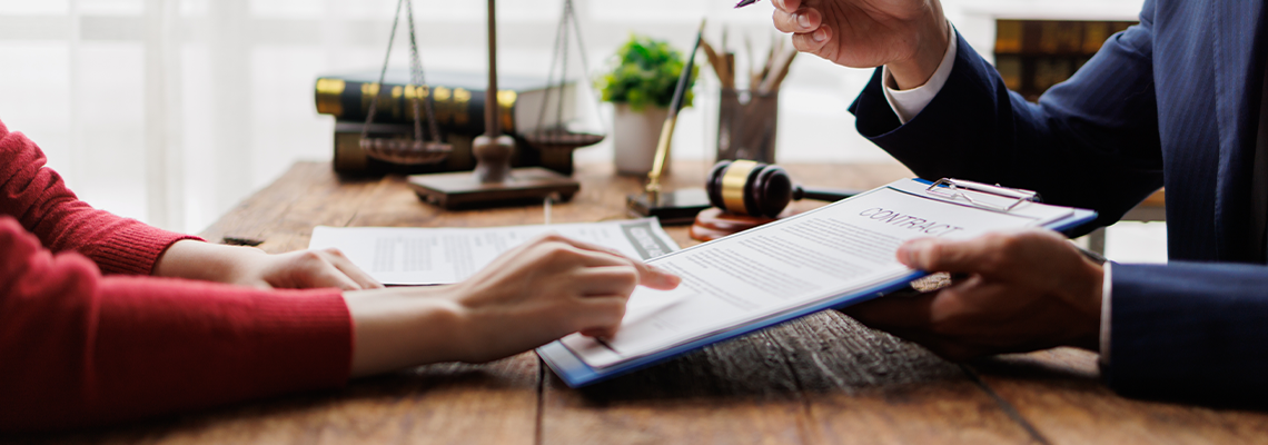 Lawyer advising client on a contract, pointing to legal document details