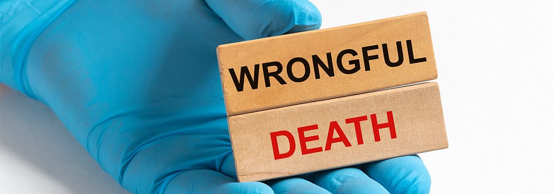 Wooden cube with Wrongful Death inscription in doctor hand