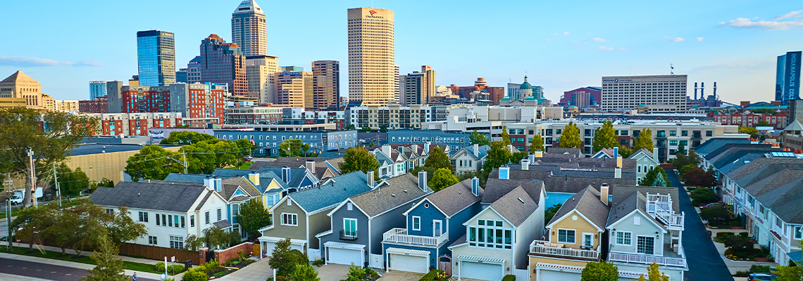 Aerial Suburban Homes and City Skyline at Golden Hour