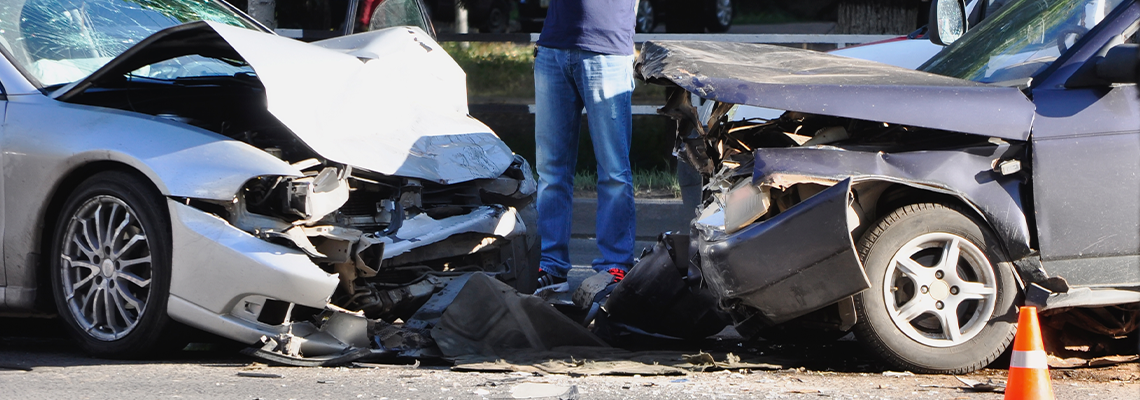 A Person Standing Between Two Crashed Car