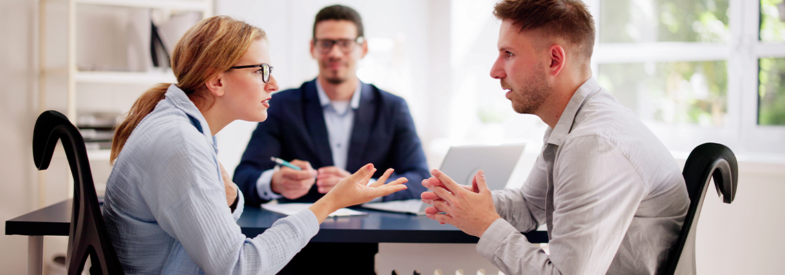 Professional lawyers mediating a tense argument between a young Hispanic couple