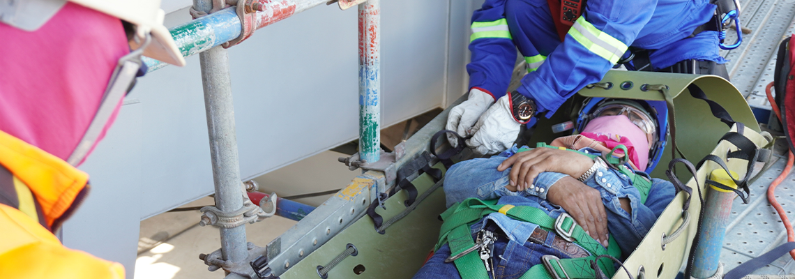 Injured workers encapsulate by sked stretcher to take off scaffolding