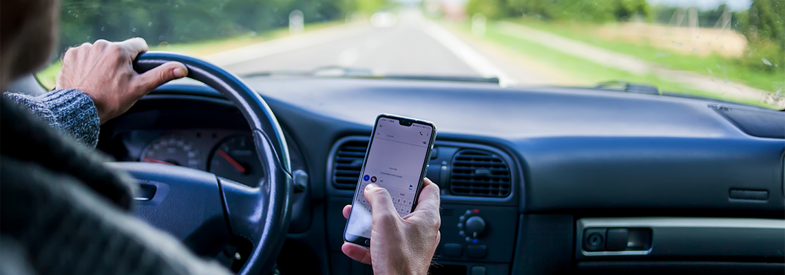 A man use smartphone while driving in the car