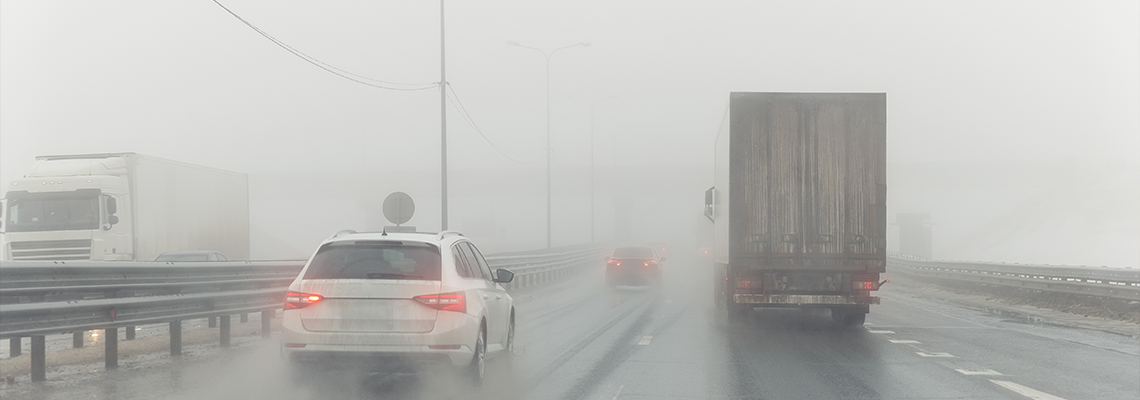 Driver POV on traffic on blue foggy misty rainy slush highway intercity road