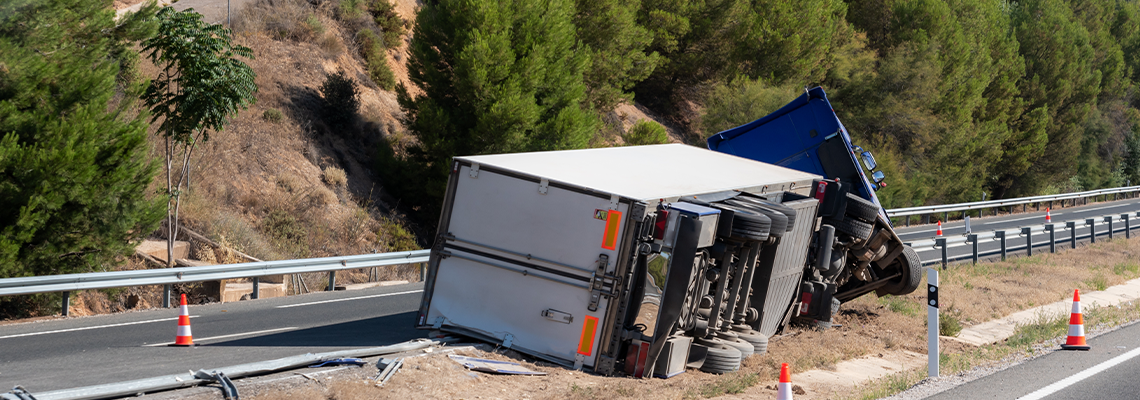 Truck with an accident refrigerated semi-trailer, overturned by the exit of the highway