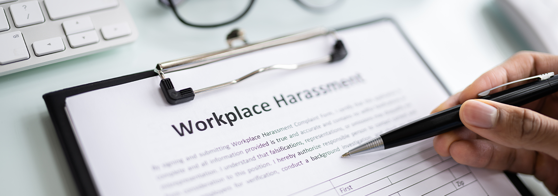 Human Hand Filling Sexual Harassment Complaint Form With Pen