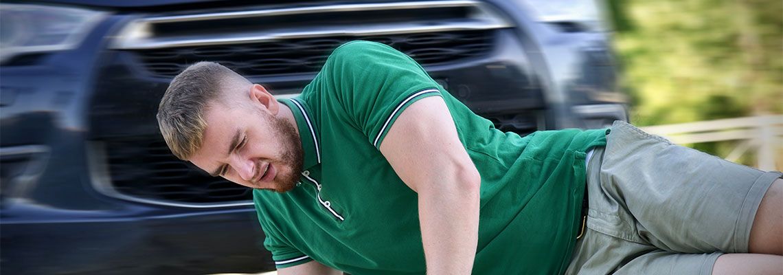 Pedestrian lying on road after accident with car