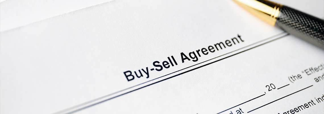 Legal document Buy-Sell Agreement on paper with pen