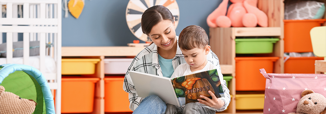 Nanny and little boy reading interesting book in room