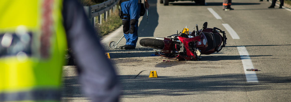 Red sport motorcycle crash scene on an open road in afternoon