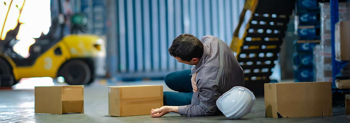 Emergency situation showing senior staff lying injured on warehouse floor
