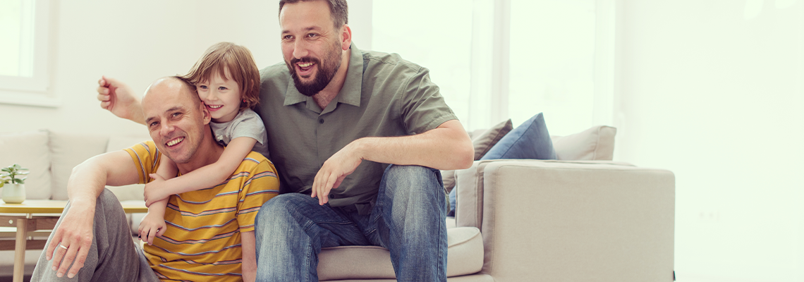 Portrait of male gay couple with adopted child