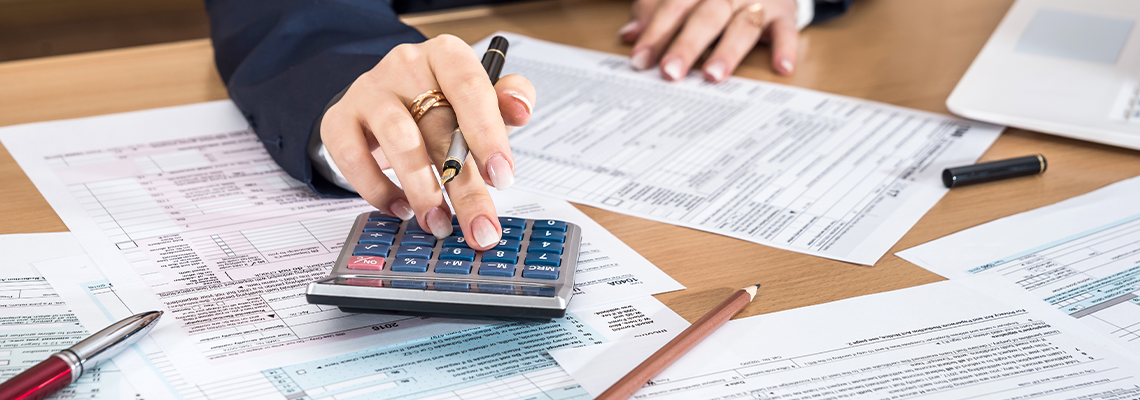 Woman filling US 1040 tax form 2018 year with calculator