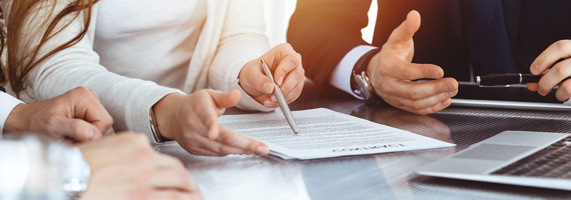 Business people discussing contract while working together in sunny modern office