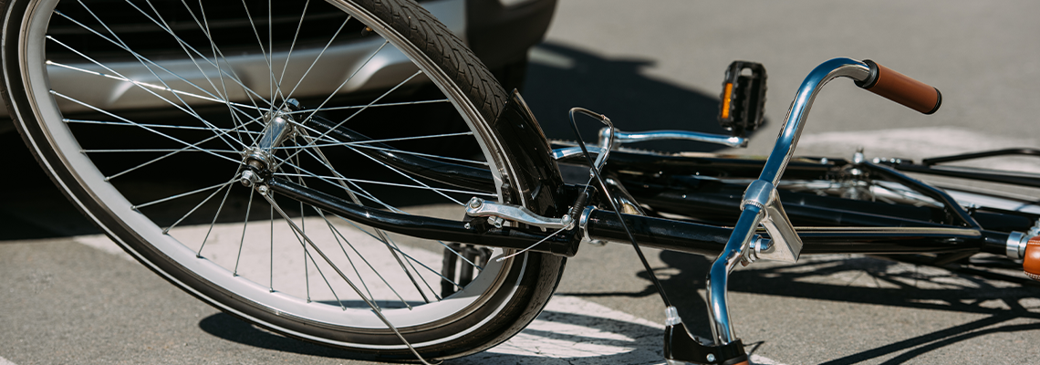 Close up view of broken bicycle and car on road