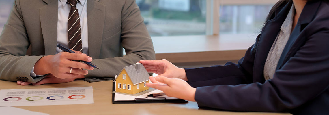 Business professionals discuss real estate property investment house model