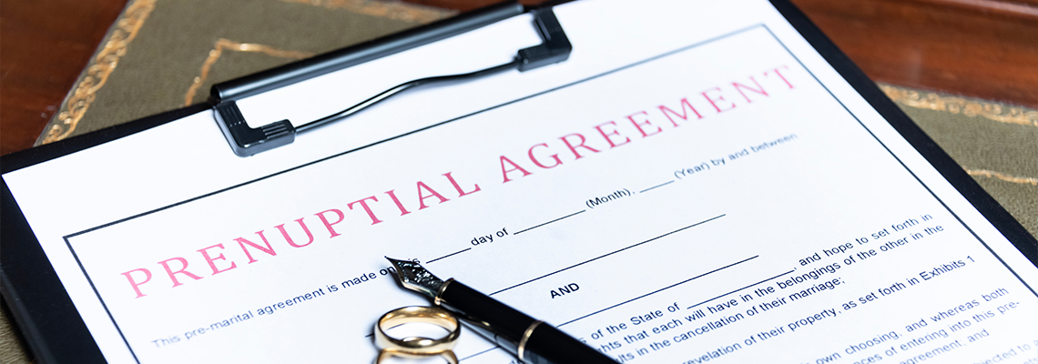 Prenuptial agreement form with wedding rings and a fountain pen