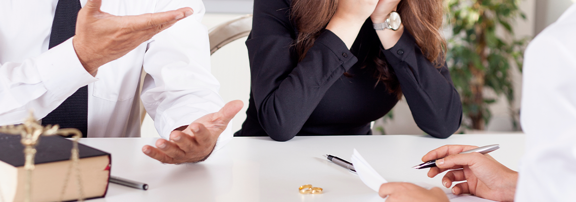 Partial view of lawyer and client sitting at table with divorce decree
