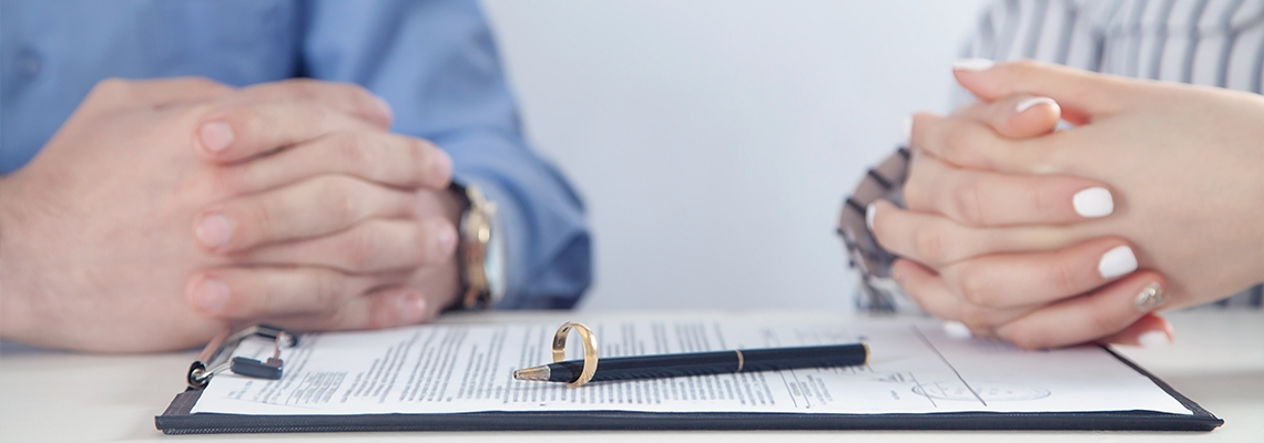 Couple with divorce contract and ring on table