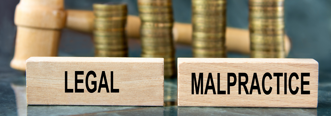 LEGAL MALPRACTICE - word on a wooden block on a background of stacks of coins