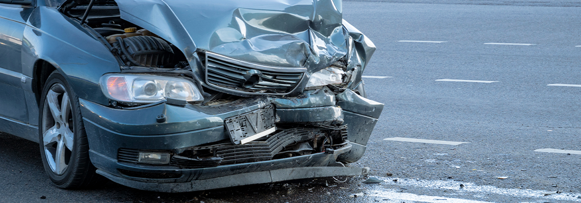 Front of dark color car damaged and broken by accident on the road