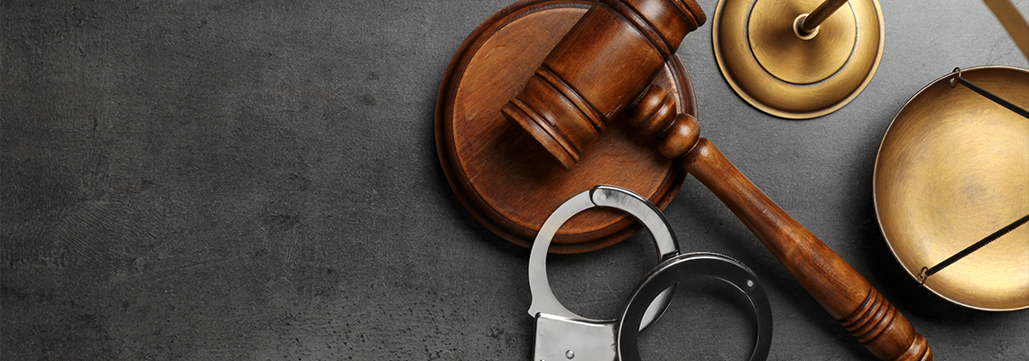 Judge's gavel, handcuffs and scales on grey background, flat lay