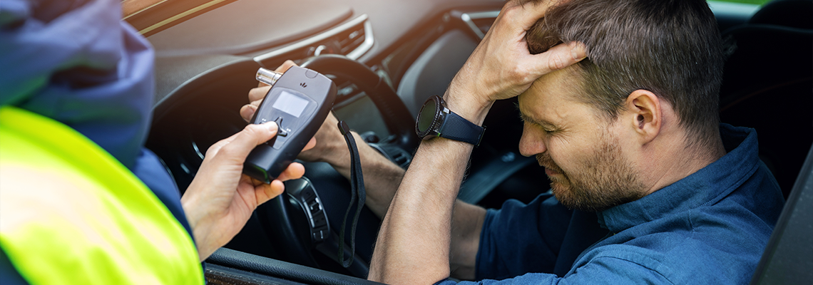 Man sitting in the car after police alcohol test with alcometer