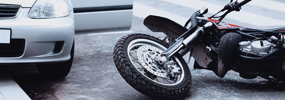 Crashed Motorcycle on road after accident with car