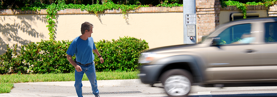 A man is jaywalking across an intersection when the signal is red