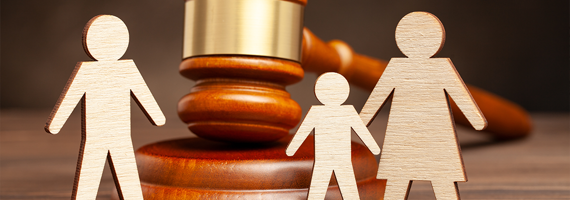 Wodden figure of Mother with child apart from father and judge's hammer.