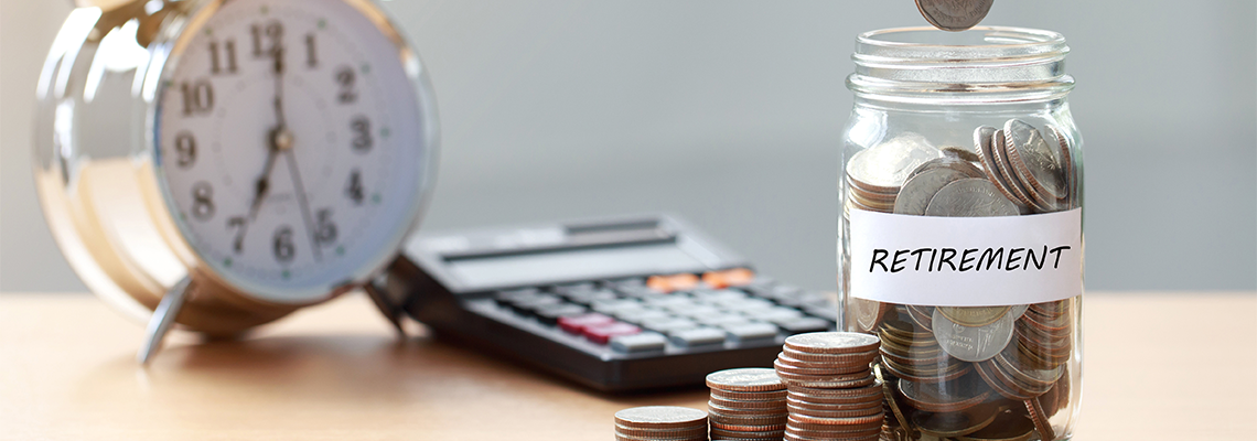 Hand putting Coins in glass jar with calculator and alarm clock
