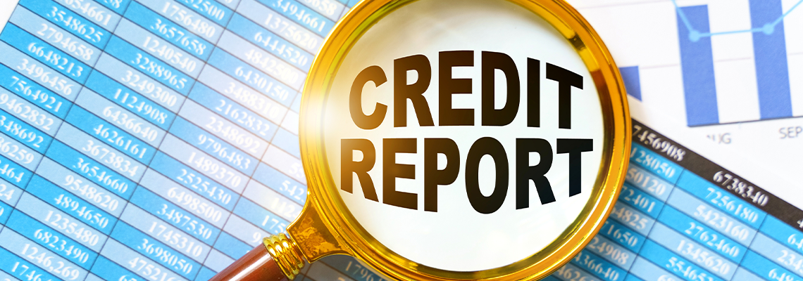 Financial reports, charts and a magnifying glass are on the table