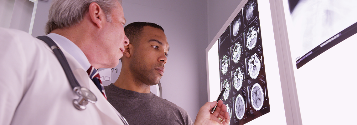 Mid aged medical doctor reviewing x ray of african patient