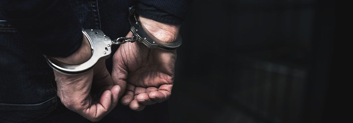 Handcuffed hand of man behind his back