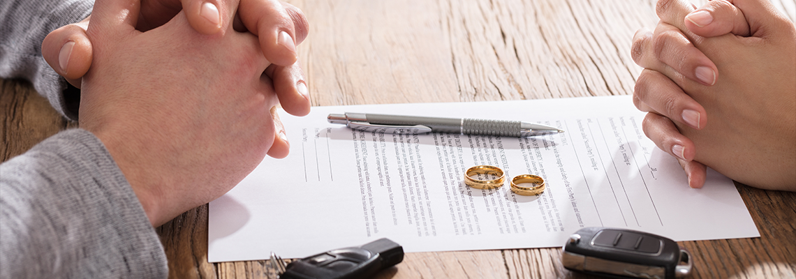 Couple's Hand On Divorce Agreement With Car Keys