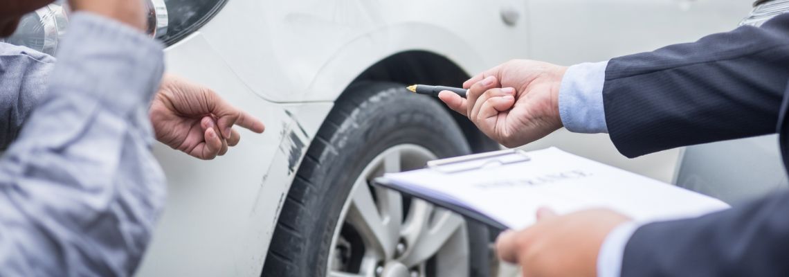 Insurance agent examining car damage after accident