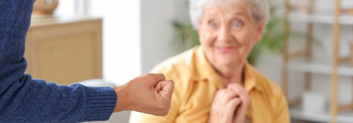 Care giver with closed fist and scare old women in nursing home