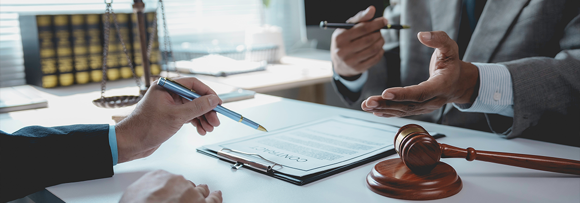 Legal professionals reviewing contract documents, gavel
