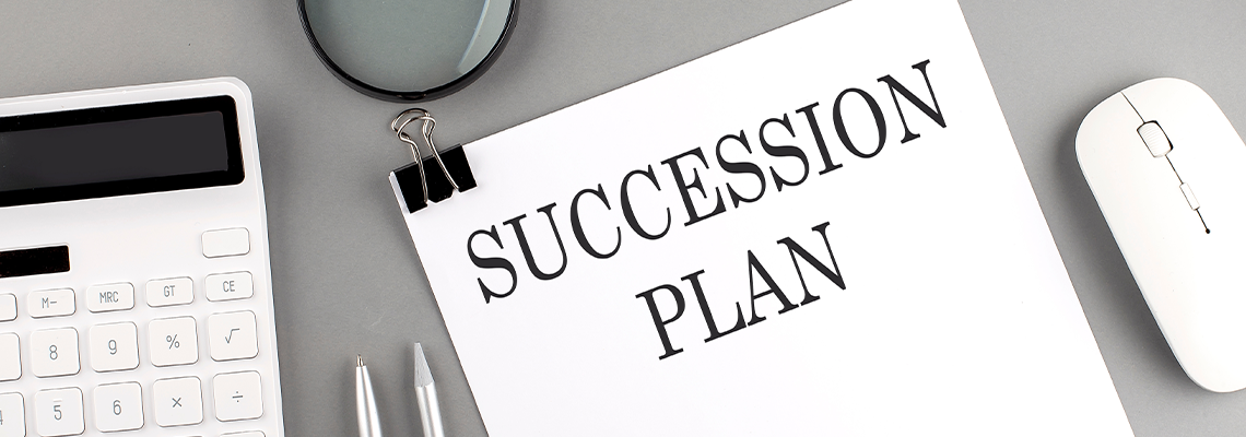 SUCCESSION PLAN written on paper with office tools and keyboard