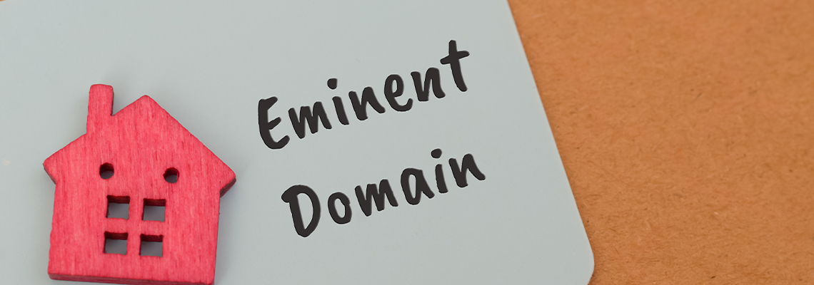 EMINENT DOMAIN written on paper with figure of house