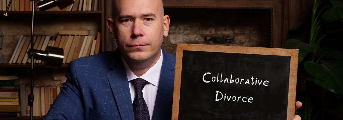Hand holding chalkboard with phrase Collaborative Divorce