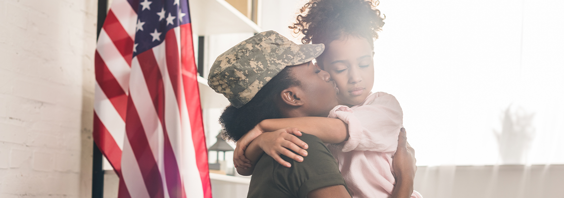 Woman in camouflage clothes kissing her daughter