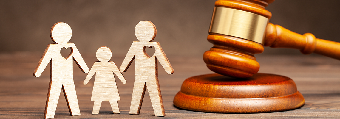 Two gay men hold hands and a child and a judge hammer
