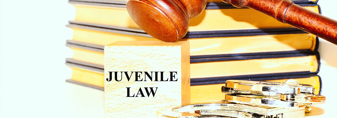 Judge's gavel , books, handcuffs and the word 'Juvenile Law'