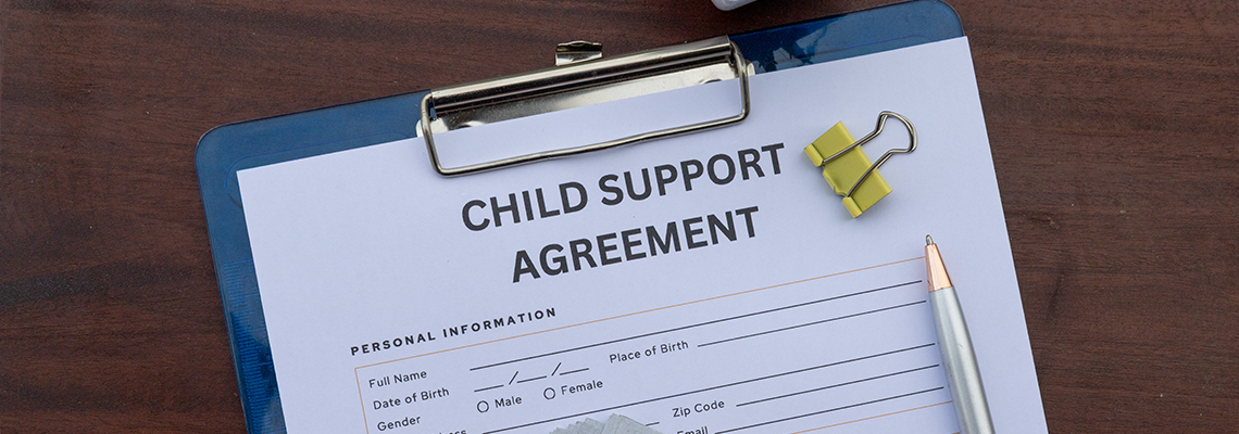 A formal child support contract placed in a clipboard on an office desk