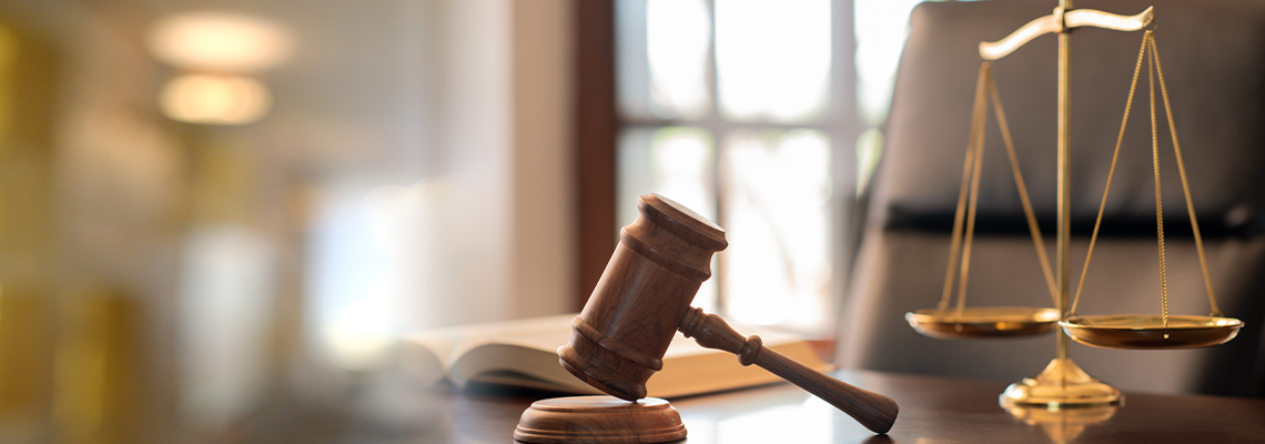 judge gavel, law books and scales of justice on desk in lawyer office