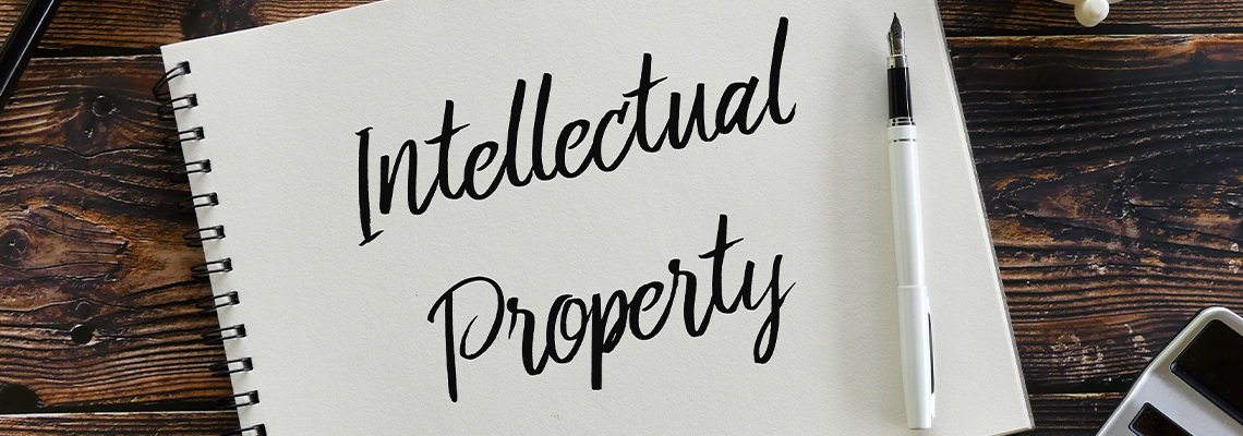 Plant,calculator,clock,pen and notebook written with Intellectual Property