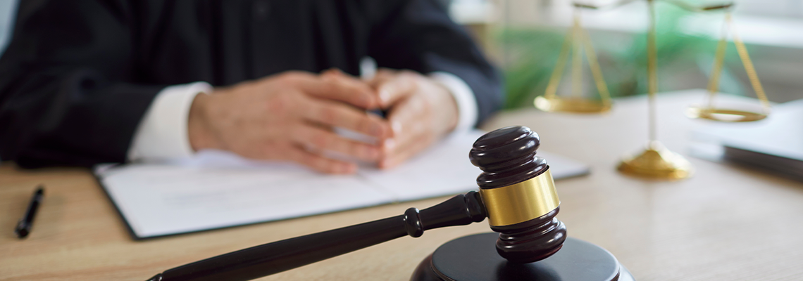 Close-up of gavel, hammer or mallet with judge in courtroom during lawsuit session
