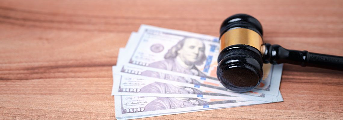 Gavel and Dollars bill in table